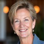Portrait of Sarah, a smiling woman in her late 40s.
